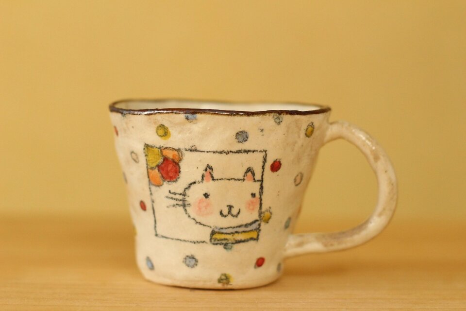 粉引き手びねりカラフルドットとねこのカップ。