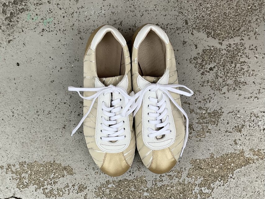 シャンパンゴールドが上品に輝くレザースニーカー｜大人カジュアルに