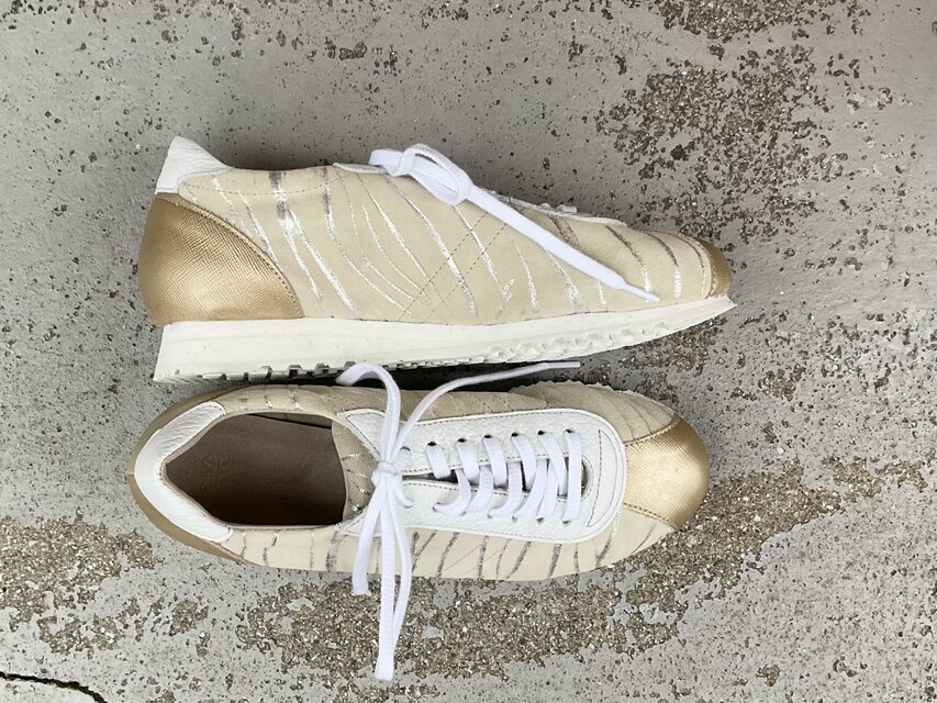 シャンパンゴールドが上品に輝くレザースニーカー｜大人カジュアルに