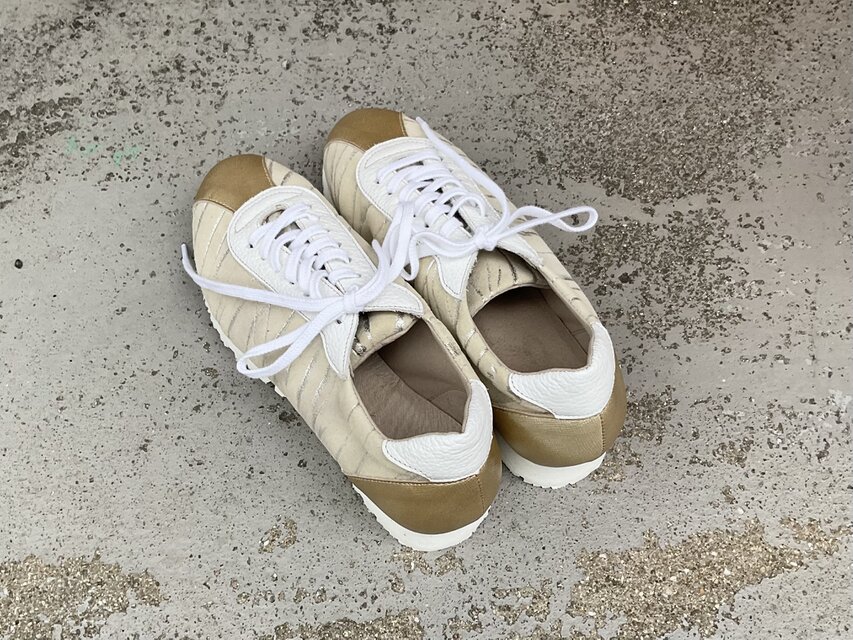シャンパンゴールドが上品に輝くレザースニーカー｜大人カジュアルに