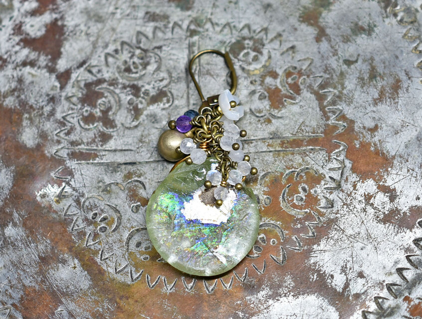 ラウンド銀化ローマングラスとたわわなストーンビーズ、白蝶貝の小花、民族鈴の片耳ピアス