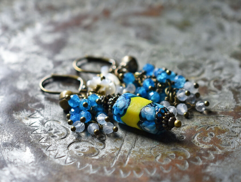 アンティークミルフィオリビーズとたわわなアパタイト＆ムーンストーン、白蝶貝の小花、民族鈴のアンシメトリーピアス