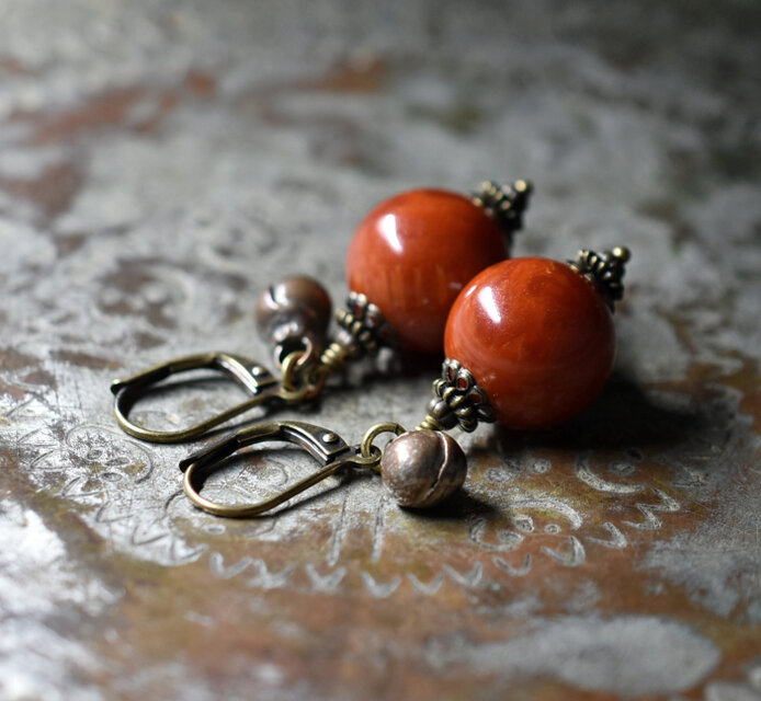 珊瑚色まん丸アフリカンアンバーと民族鈴のピアス(1.4ｍｍ)