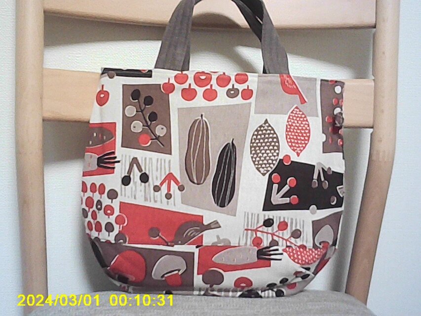 オックスベージュ地に４色使い柄のまる底手提げ