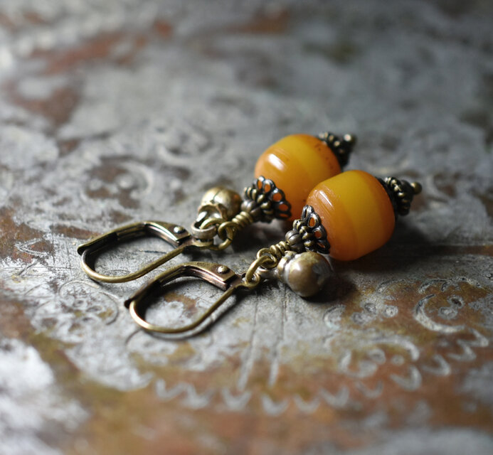 ツートン琥珀色アフリカンアンバーと民族鈴のピアス（楕円） | iichi