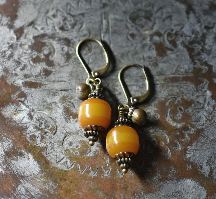 ツートン琥珀色アフリカンアンバーと民族鈴のピアス（楕円） | iichi