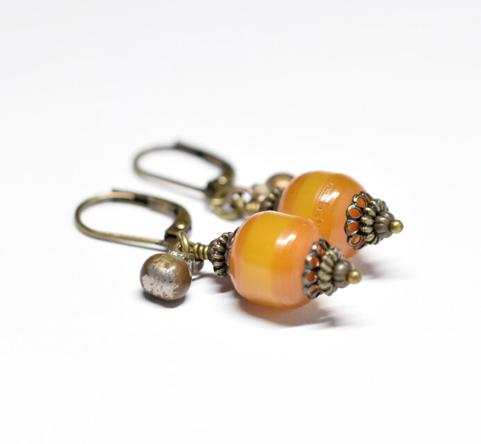 ツートン琥珀色アフリカンアンバーと民族鈴のピアス（楕円） | iichi