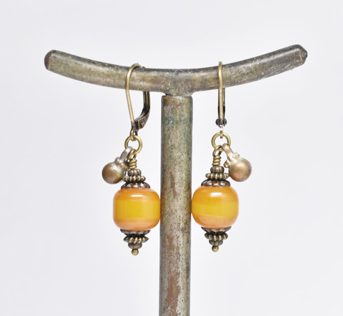 ツートン琥珀色アフリカンアンバーと民族鈴のピアス（楕円） | iichi