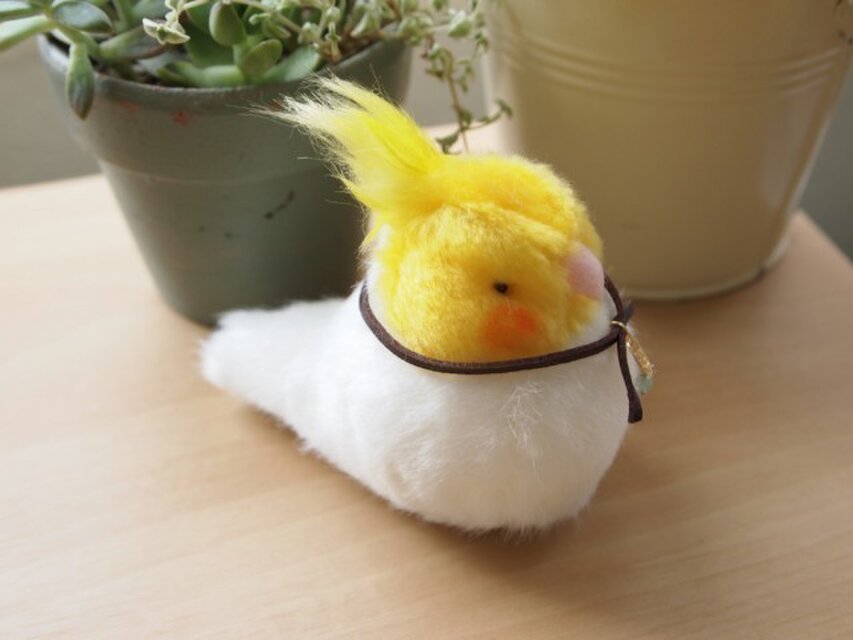 手のひらサイズのぬいぐるみオカメインコねむたげな白