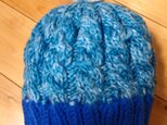 【値下げ 】 フラワーモチーフのポンポン(？)がカワイイ　ブルーの 縄編みニット帽　の画像