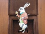 時計を見つめるウサギのブローチの画像