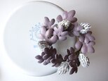 紫の葉と白い実のリースコサージュの画像