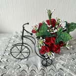 小さな自転車の籐の花（赤のカーネーション）