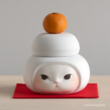 シロ猫　鏡餅（かがみもち）のかぶりものをした猫の置物　陶土・陶器の画像