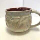 淡いピンクに色付く草模様オシャレなコーヒーカップの画像