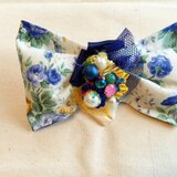 アシメトリーなリボン風の花柄コサージュ