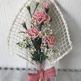 籐で編んだ小さな花束（ピンク色のカーネーション）の画像