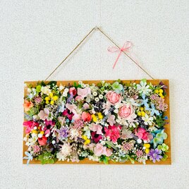 ピンク色のお花畑の壁飾りの画像