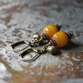 ツートン琥珀色アフリカンアンバーと民族鈴のピアス（楕円）