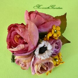 A corsage of five roses and yellow flowers