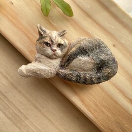 木彫りの「見えない音を聞く猫」のブローチ
