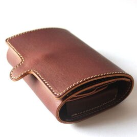 くるむように包まれた3つ折りレザー財布。