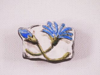 陶器の帯留め-青色ガーベラの下絵付けの画像