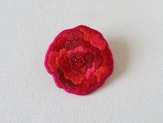 赤い花のブローチの画像