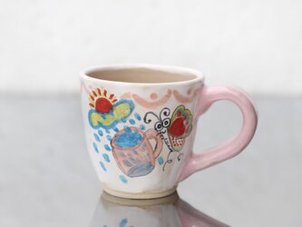 カップを運ぶ蝶絵のマグカップ（ピンクの取っ手）の画像