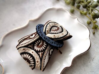刺繡リボンのポニーフック ■ フレーム＆リボンデザイン ■ 茶色と黄金色の円形　民族衣装柄の画像