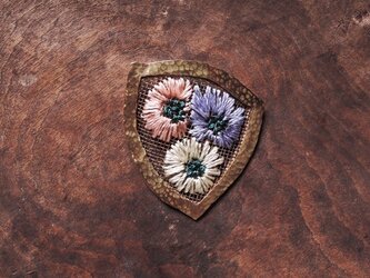 ポケットに花の刺繍ブローチの画像
