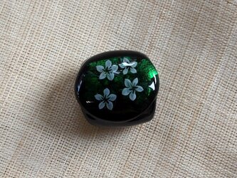 白い小花の帯留（緑）の画像