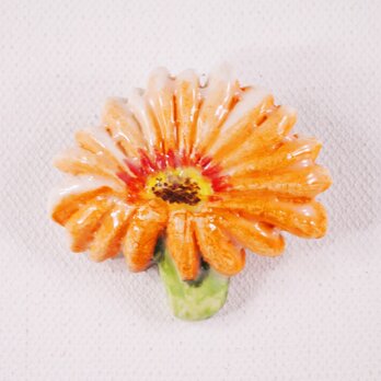 陶器ブローチ-橙色ガーベラのレリーフ＆下絵付けの画像