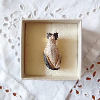 座っているハチワレ猫の陶土ブローチの画像