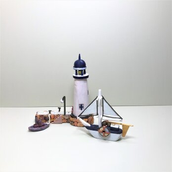 青い灯台と白い船の画像