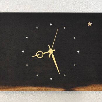 ウェンジの朝焼けのような木目にスワロフスキーの明けの明星が輝く木の掛け時計の画像