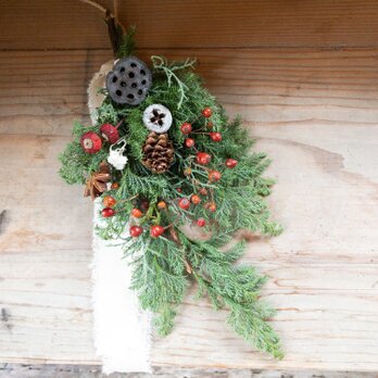 針葉樹と蓮の実や赤い実とかわいい小さな白い花カワラハハコなどのクリスマススワッグの画像