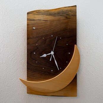 三日月を楽しむ木の掛け時計の画像