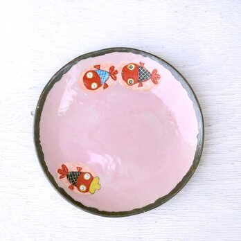 黄色い帽子をかぶった赤い金魚とピンク釉の色絵皿の画像