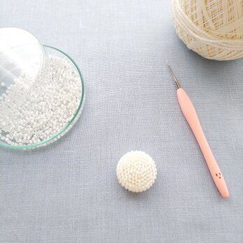 ビーズ編みの飾りボタン  ヘアゴム加工／白にオーロラの画像