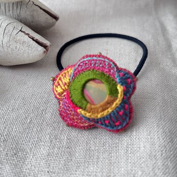 マーブル模様のパーツを刺繍で包み込んだお花みたいなヘアゴムの画像