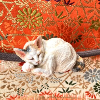 木彫りの眠り猫の帯留の画像