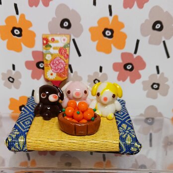樹脂で作った小さな々わんちゃん３匹とミカンの画像