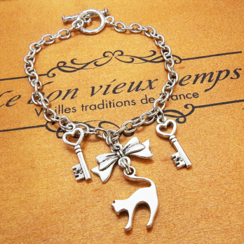 アンティークシルバー 跳ね猫シルエットモチーフとリボンに鍵が連なるブレスレット