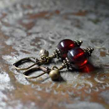 まん丸な柘榴色アフリカンアンバーと民族鈴のピアス