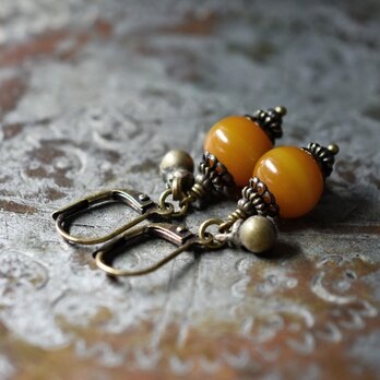 ツートン琥珀色アフリカンアンバーと民族鈴のピアス（丸）