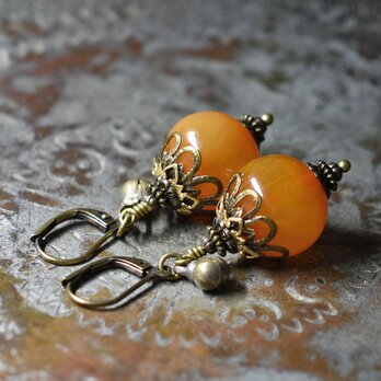 まん丸艶やかなアフリカンアンバーと民族鈴のピアス（淡）