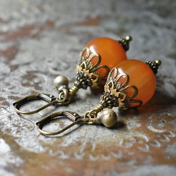 まん丸艶やかなアフリカンアンバーと民族鈴のピアス（濃）