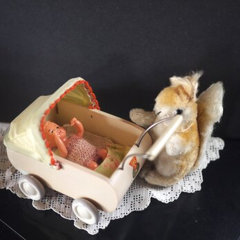 木製ベビーカーとピンクのベビー服の女の子