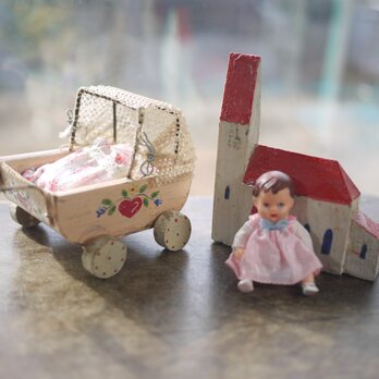 木製ベビーカーとピンク服の女の子 ドイツ